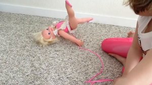 кукла-балерина стоит на голове и делает шпагат.doll ballerina does the splits herself