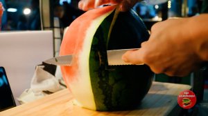 Кореец уверенно держит нож в руках и умело нарезает фрукты