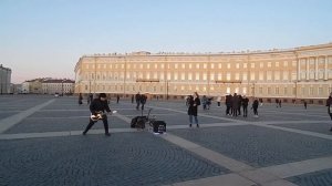 Соло на гитаре исполняет уличный музыкант Николай Музалёв на Дворцовой площади в Санкт-Петербурге..