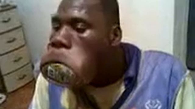 Негр крутит  банку во рту