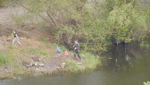 Рыбак с удочкой с двумя детьми удил рыбу на реке Мокрая Мечётка, Волгоград, Спартановка