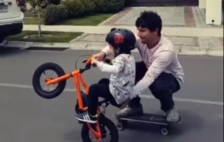 Папа учит сына кататься на велосипеде
