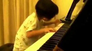 Способный ребенок играет на пианино