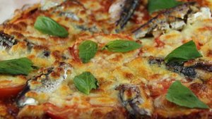 Пицца на кукурузном тесте с сардинами, томатами и моцареллой