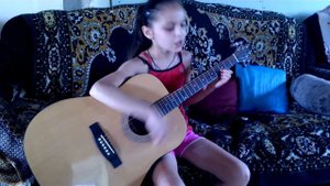 девочка играет на гитаре и поет