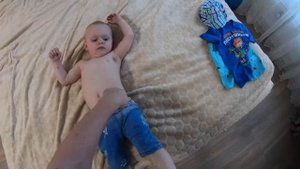 Папа пытается одеть сына на прогулку, но сын хочет смотреть мультики :)