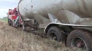 Вытаскивает огромную машину из грязи