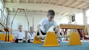 Выполнение упражнений на брусьях. Детская гимнастика. Минск.