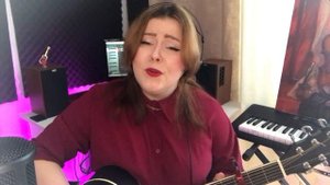 Девушка поёт песню "Кукушка" под гитару.