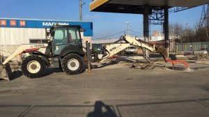 Экскаватор погрузчик Terex 970 Elite демонтирует бетонное основание заправки в Калуге