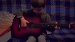 Маленький  мальчик Играет на гитаре) ему 2 года)