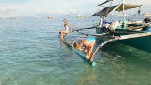 Children on the beach jump into the sea from a boat 4K