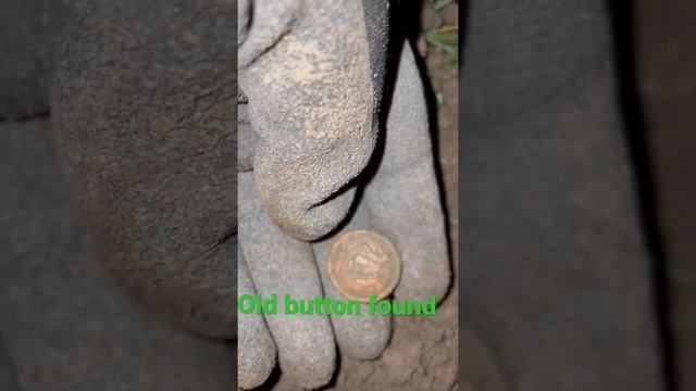 Old button found metal detecting old baseball field. Treasure hunting