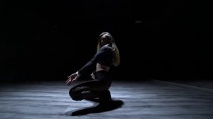 Девушка в черном танцует на высоких холмах