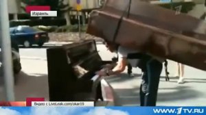 Пианист Силач виртуозно играет,С пианино на спине.