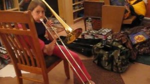 Kid playing trombone with her foot