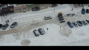 Трактор чистит двор от снега