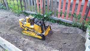 бульдозер на радиоуправлении Bruder выкапывает яму