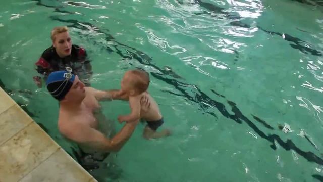 Ныряет и плывёт с инструктором под водой поперёк бассейна смотреть онлайн