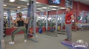 Приседания со штангой в тренажере Смита с широкой постановкой ног