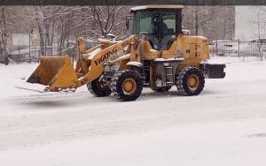 Дорожная техника проезжает мимо неочищенных автобусных остановок с гордо  поднятыми ковшами.