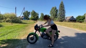Красивая девушка заводит мотоцикл Восход