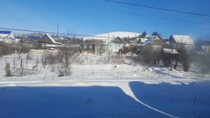 Зимний пейзаж из окна поезда на посёлок Усть-Катав зимой днём в небольшой горной местности деревня
