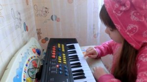 Маша учится играть мелодии на детском синтезаторе.