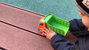 Малыш Саша играет на детской площадке с машинкой - машинка самосвал