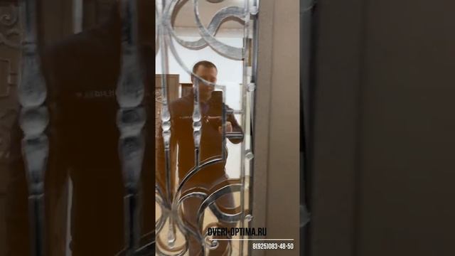 Уличная термодверь с металлической филенкой и кованой решеткой.