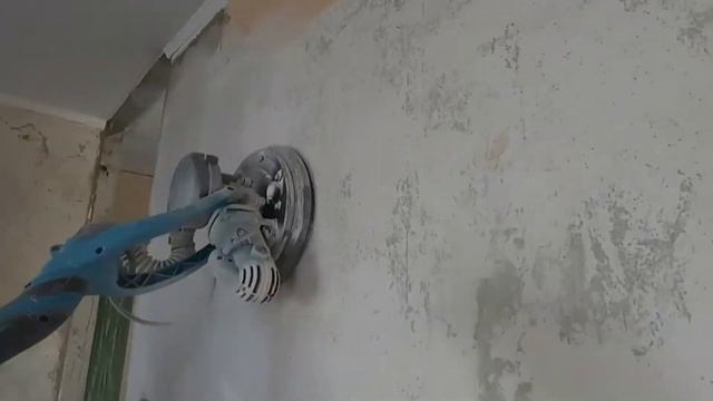 шлиф машинка жираф в работе при зачистке побелки. grinder machine giraffe at work