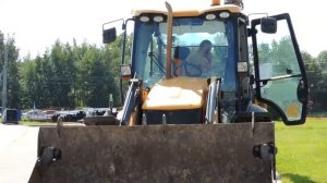 Экскаватор погрузчик тащит трубы