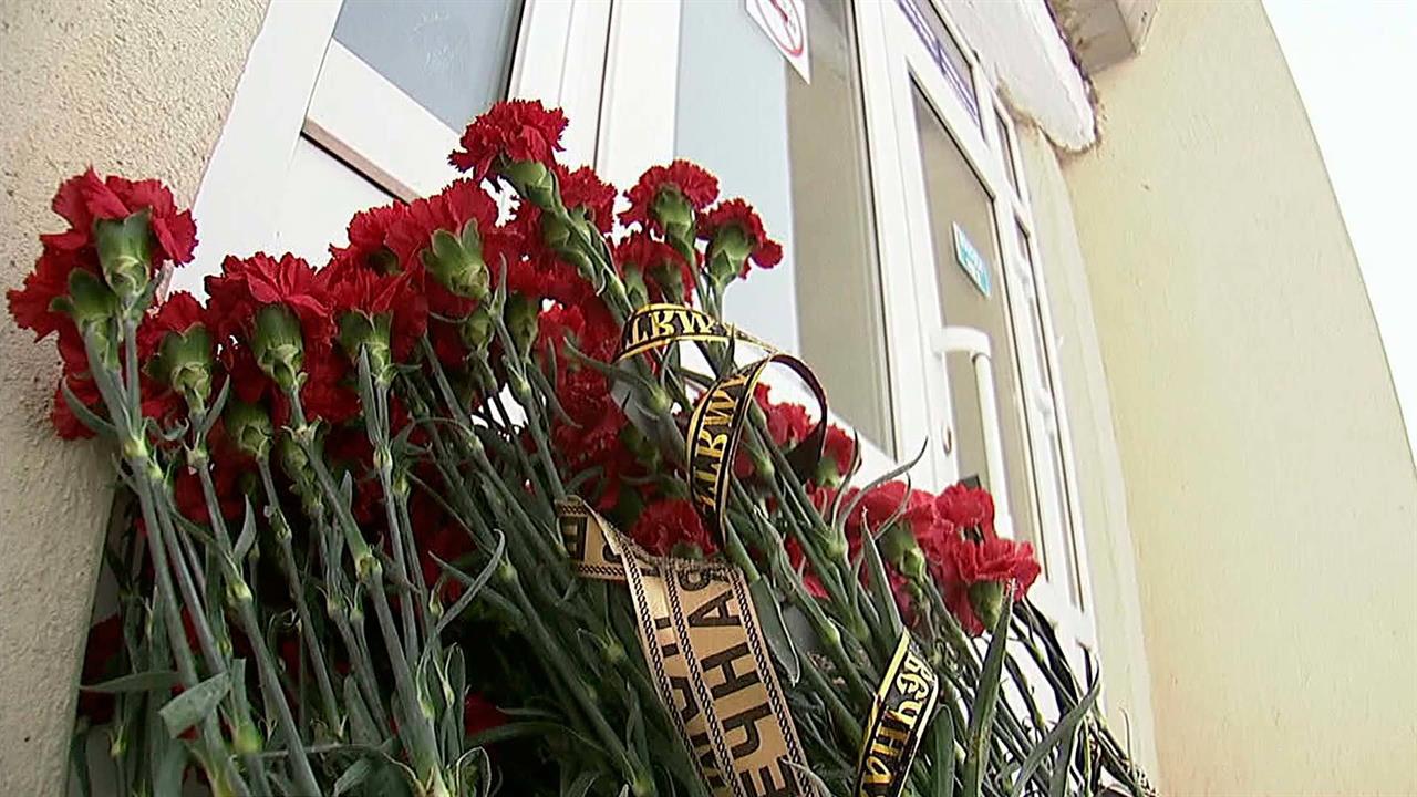 Жители Орска несут цветы и свечи в центр города к фотографии самолета "Москва-Орск"