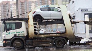 С автовоза съезжает машинка - Renault Sandero
