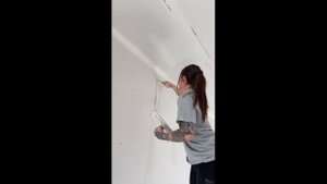Маляр-штукатур на ходулях работает