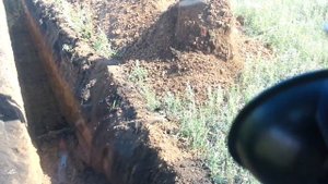 Экскаватор копает траншею под водопровод