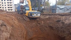 копать глубоко яму с экскаватором JCB