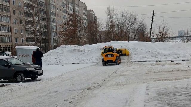 Уборка снега с автомобильной парковки погрузчиком JCB со снегоуборочным отвалом (ч.1) смотреть онлайн