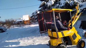 Мини погрузчик чистим снег во дворе.