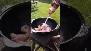 Картошка с мясом в казане на открытом огне.