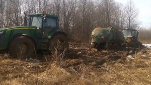 4 john deere буксуют в грязи. Вытаскивают трактор с бочкой из жижи