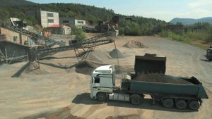 Погрузчик загружает Камаз