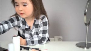 Make up: маленькая девочка сама себе делает макияж.