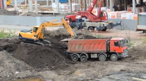 Экскаватор держит борт у Красного Самосвала Мерседеса, чтобы вычистить не нужный грунт.