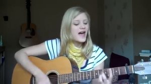 Красиво играет на гитаре и поёт французскую песню.