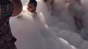 Мистер Лев купается в пенном бассейне.