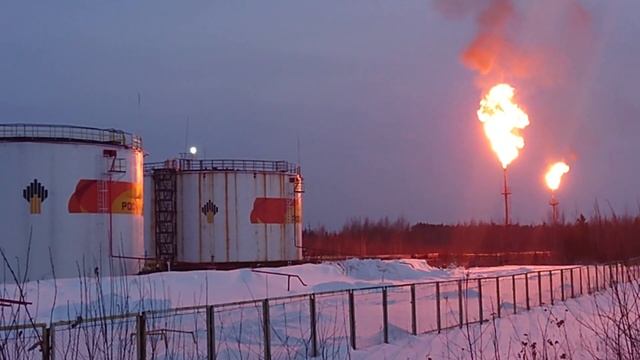 факел сжигания газа и контейнер с майнерами рядом