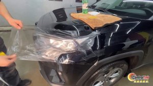 Процесс наклеивания защитной пленки на фары автомобиля.