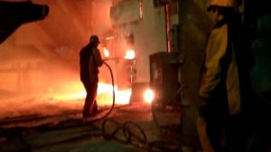 Сталевар кислородом подрезает горловину конвертера