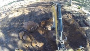 Трактор копает котлован на загородном участке